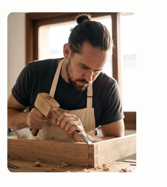 Geste de l'artisan sur le plateau d'un banc en bois massif